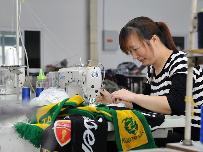 Factory ... A factory worker makes Australia scarves for the 2014 FIFA World Cup